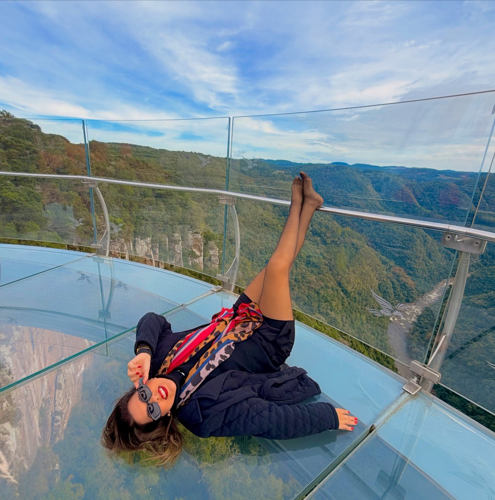 Pessoa deitada na plataforma de vidro transparente do Skyglass Canela